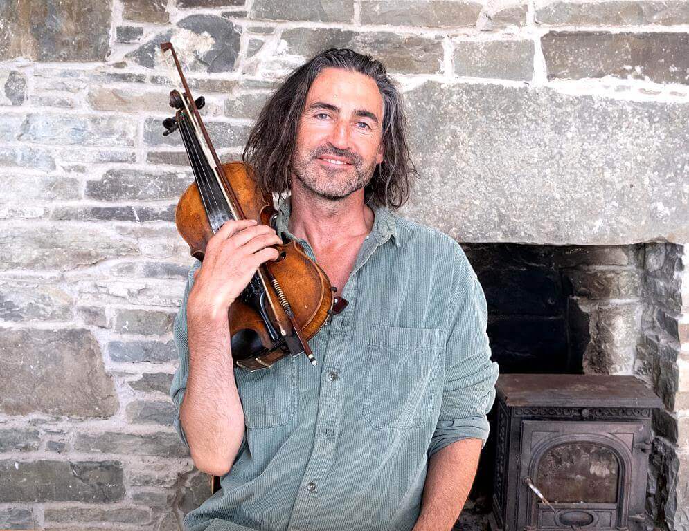 Photo of AINDRIAS DE STAIC holding a violin.